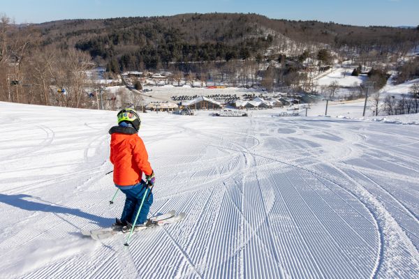 A young boy skiing a groomed run. Click here for FAQs of Catamount Resort.