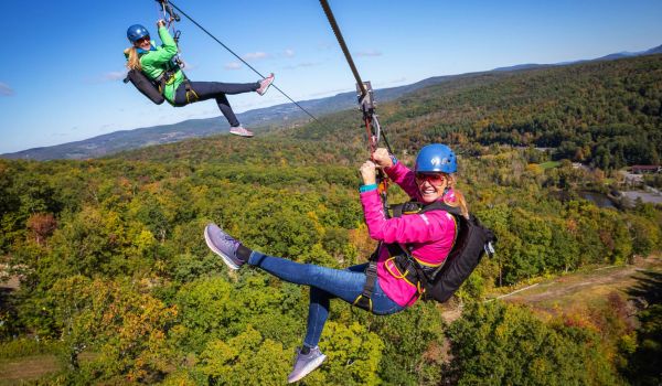 Two smiling ladies on the zipline at Catamount Resort