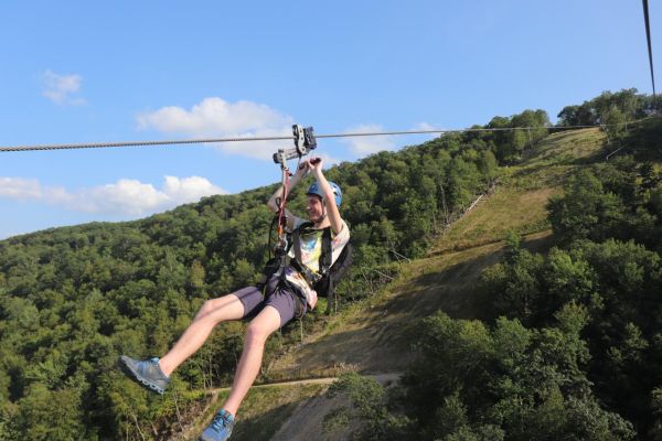 A teenager riding the zipline at Catamount Resort