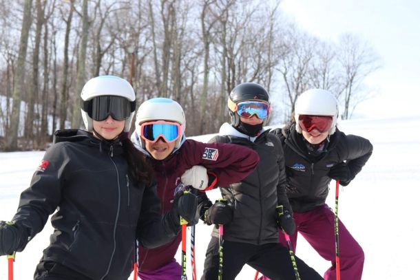Four ski racers posing for a photo at Catamount Ski Resort