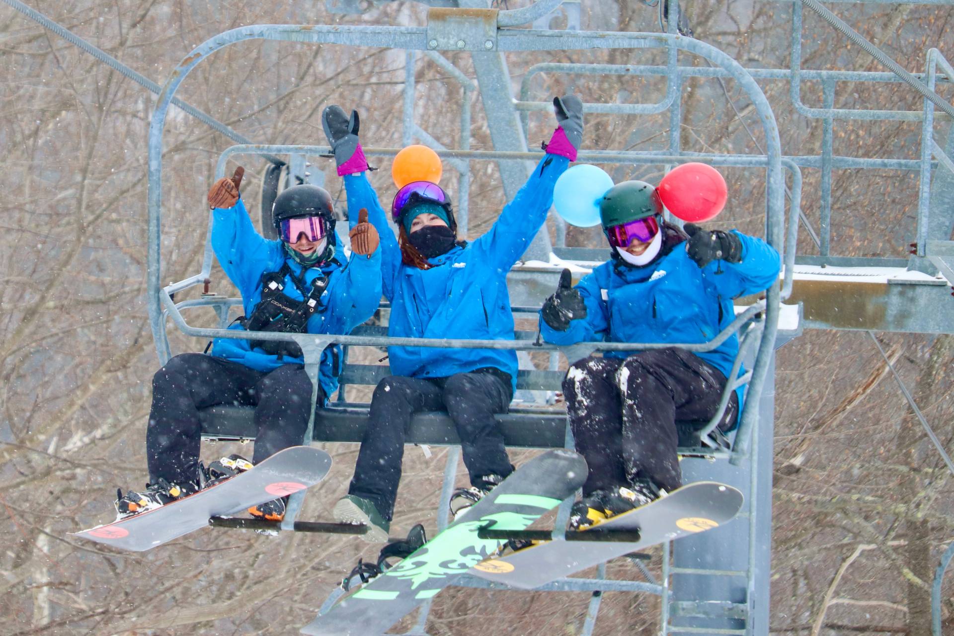 3 employees riding chairlift