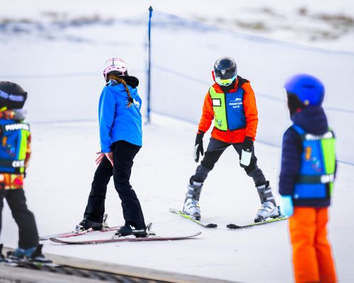 Three young skiers learning how to ski in the Mountain Cats Program