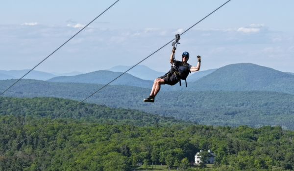 A man stopping on the zipline at Catamount Resort
