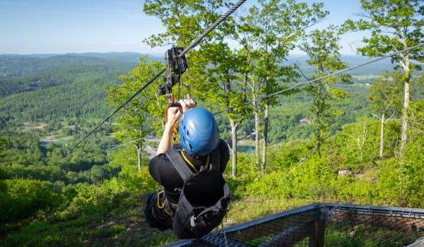 A man launching off the top of the Catamonster Zipline at Catamount Mountain Resort
