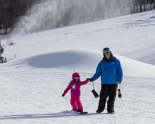 Catamount Snow Sports Instructor guiding child down the learning slope