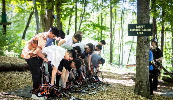 An adventure park group going through the harnessing process together