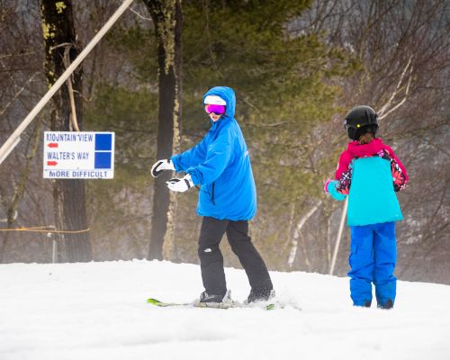 A large group of kids smiling with their ski instructors at Catamount Ski Resort