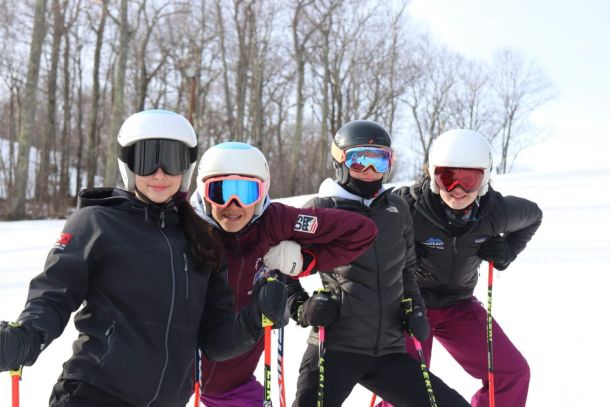 Four ski racers posing for a photo at Catamount Ski Resort