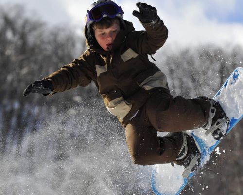 A young snowboarder taking a jump at Catamount Ski Resort