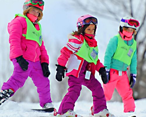 Three young skiers learning how to ski in the Mountain Cats Program