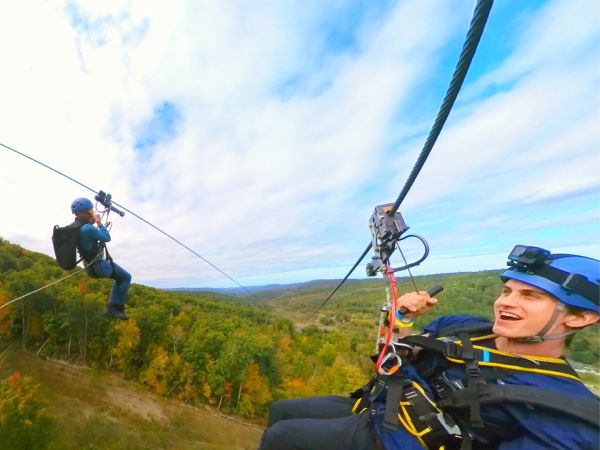 A person on the zipline above the trees.